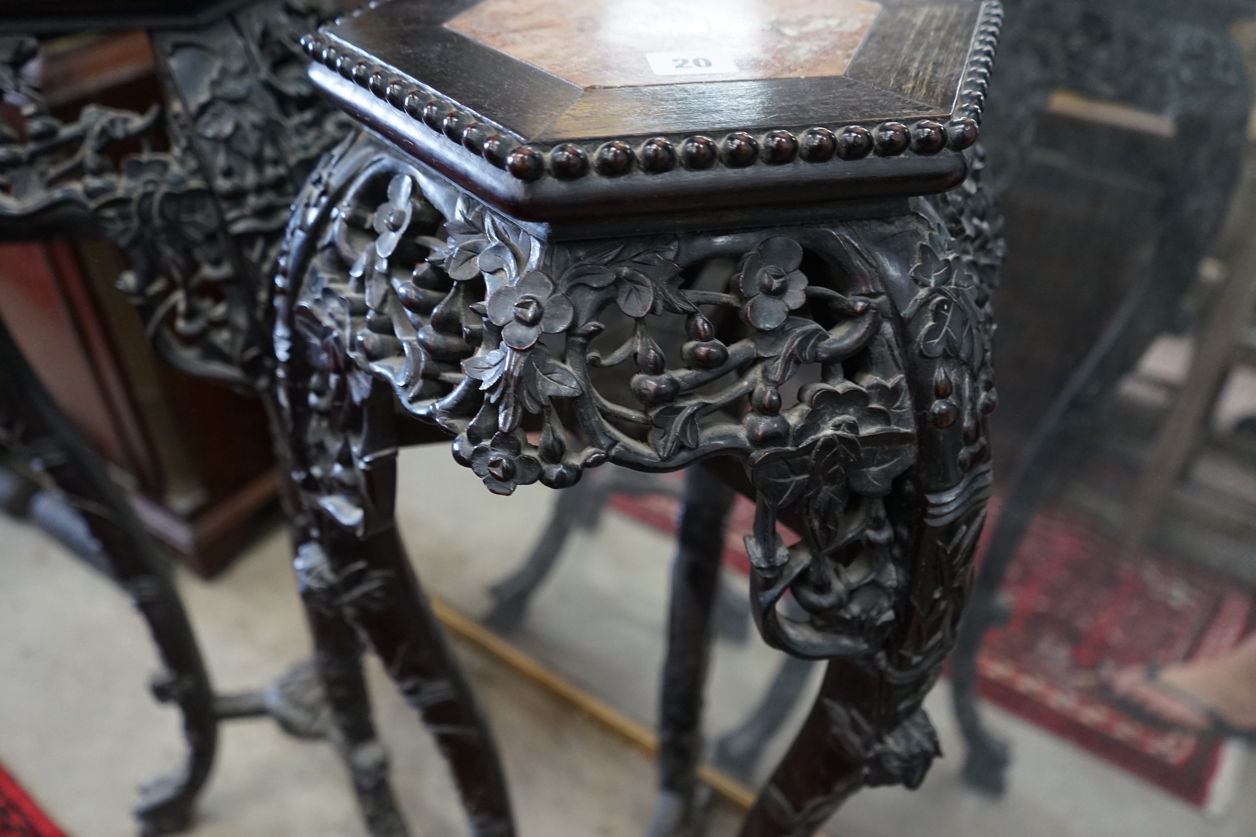 A pair of Chinese carved hardwood hexagonal marble topped vase stands, height 91cm